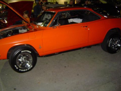 1979 Ford Bronco - An orange coupe is parked outside with its hood open, showing the engine bay.