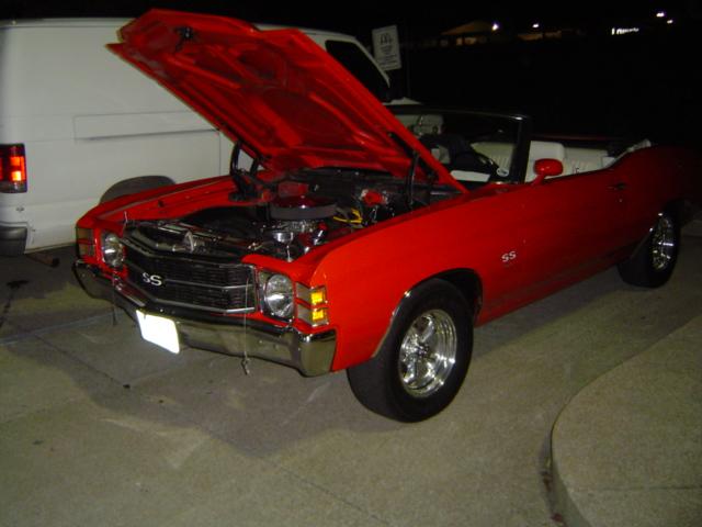 Red convertible with SS badging and hood open, showing engine
