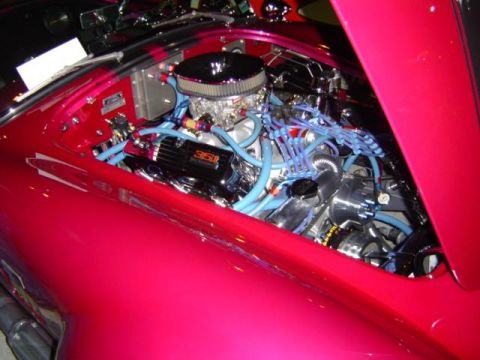 1979 Ford Bronco - Custom V8 engine bay with bright pink bodywork and extensive blue wiring.