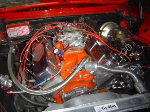 1979 Ford Bronco - The engine bay of a red vehicle, showing a V8 engine with performance upgrades like an MSD ignition and Holley carburetor.