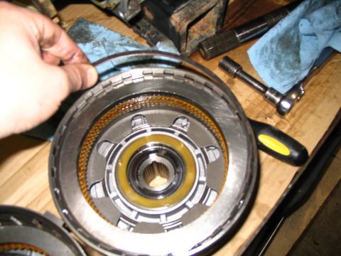 1984 Ford Bronco - Close-up of a transmission torque converter clutch assembly being worked on, with tools and rags visible on a wooden surface.