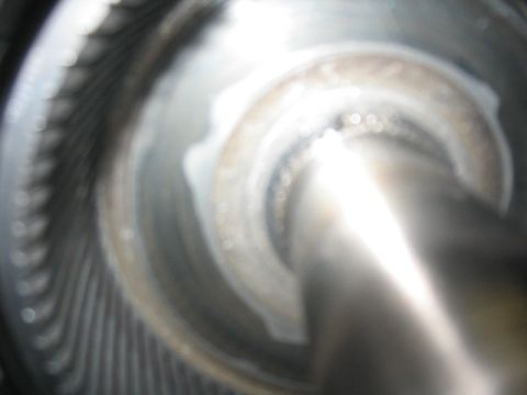 1984 Ford Bronco - A close-up view of a metallic transmission component, possibly a torque converter or clutch drum, showing internal fins and a central shaft.