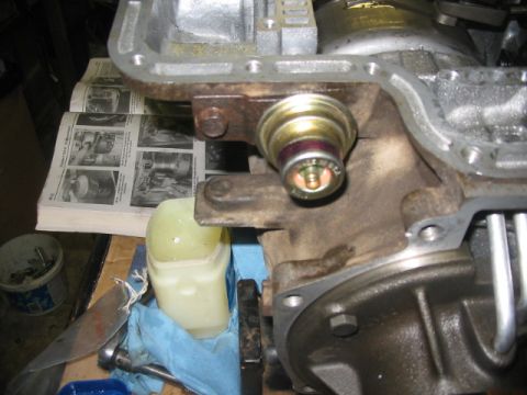 1984 Ford Bronco - Transmission sensor mounted on a metal component, with a service manual visible behind it.