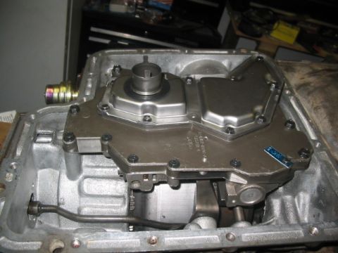 1984 Ford Bronco - Close-up view of an automatic transmission's valve body and pan assembly, revealing intricate mechanical parts.