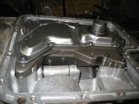 1984 Ford Bronco - The interior of an automatic transmission pan is visible with its cover removed.
