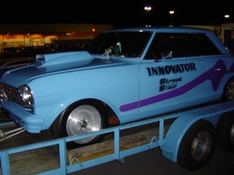 1979 Ford Bronco - A light blue custom coupe with a hood scoop is loaded onto a trailer at night.