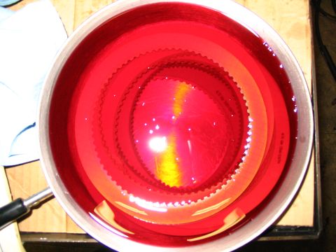 1984 Ford Bronco - A transmission clutch pack is submerged in red fluid, ready for installation.