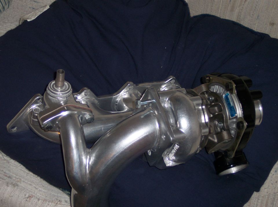Aluminum exhaust manifold with turbocharger on dark blue cloth