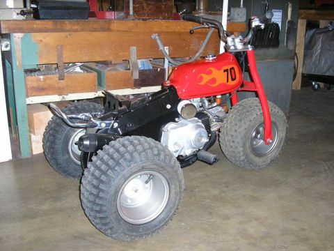1900 Honda Big Red - This three-wheeled ATV features a red gas tank with flame graphics and the number 70 displayed prominently.