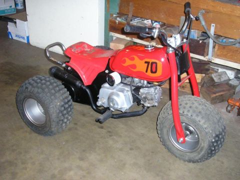 1900 Honda Big Red - This ATV has a red frame, seat, and gas tank with flame decals and the number 70.