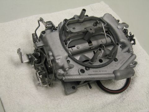 1991 Ford LTD Crown Victoria - cast-aluminum four-barrel carburetor photographed from the top-front on a white towel, showing throttle linkage and bowl.