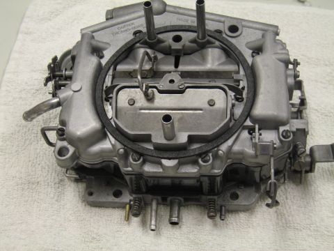 1991 Ford LTD Crown Victoria - Carter Thermoquad-style four-barrel carburetor shown from the side on a white towel, with linkage, choke, and fuel fittings visible.