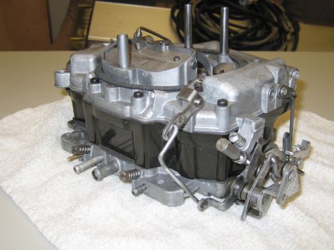 1991 Ford LTD Crown Victoria - four-barrel carburetor rests on a white towel atop a table, with coiled wiring and a metal box in the background.