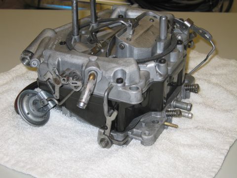1991 Ford LTD Crown Victoria - four-barrel carburetor in side profile on a white towel, with accelerator pump and throttle linkage visible.