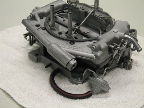 1991 Ford LTD Crown Victoria - mounting base of a four-barrel carburetor on a white towel, showing throttle plates and a gasket sealing ring.