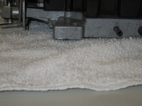 1991 Ford LTD Crown Victoria - Close-up of a carburetor body showing a cast identification number reading 6411S 203 2.