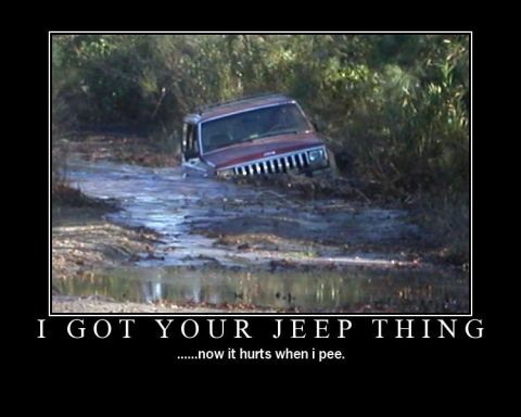 1988 Ford Bronco - A red Jeep Cherokee is stuck in a muddy, watery path surrounded by vegetation.