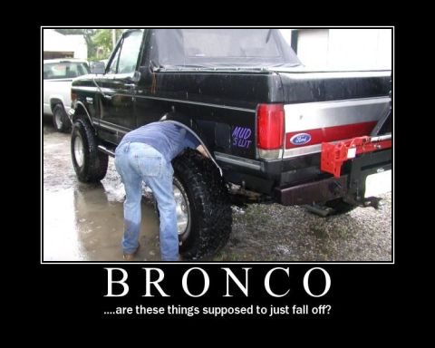 1988 Ford Bronco - Demotivational-poster graphic showing a man bent over the rear wheel of a lifted black full-size Ford Bronco with a black soft top, red rea…