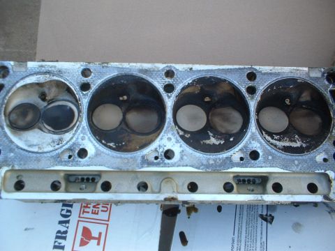 1993 Ford Bronco - Close-up view of an engine cylinder head, showing the combustion chambers and valves.