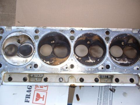 1993 Ford Bronco - Close-up of an engine cylinder head, showing valves and combustion chambers. Packaging is visible underneath.