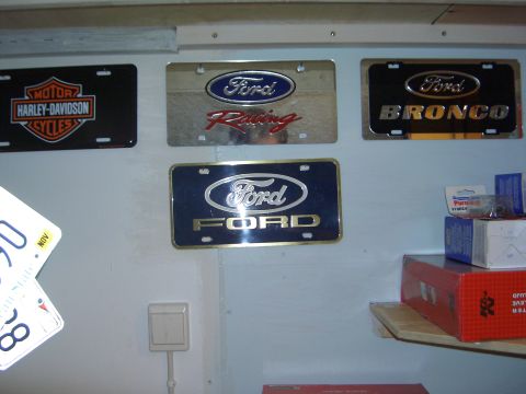 1996 Ford Bronco - Wall display features a Ford Bronco license plate among other automotive memorabilia.