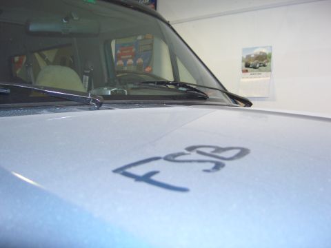 1996 Ford Bronco - The hood of a vehicle has 'FSB' written on it. The interior is visible through the windshield.