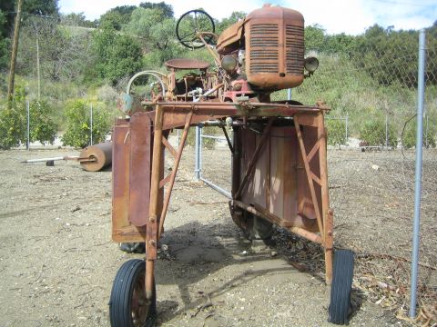 1968 Ford Mustang - This weathered tractor, seen from the front, features a prominent grille and steering wheel, suggesting its agricultural purpose.