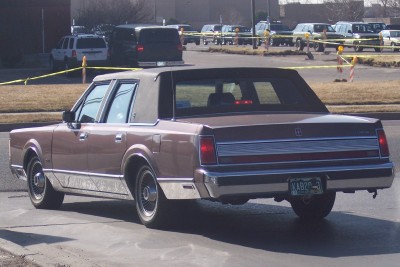 1972 Ford Ranchero - This brown sedan, likely a Lincoln Town Car from the 1970s, is seen from the rear with a vinyl roof and a license plate from 1972.