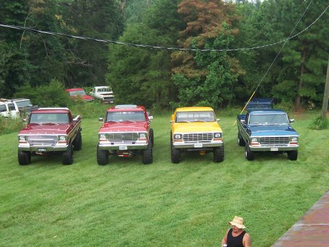 1978 Ford Bronco - A line of four Ford trucks, likely from the late 1970s, are parked on a grassy lawn.