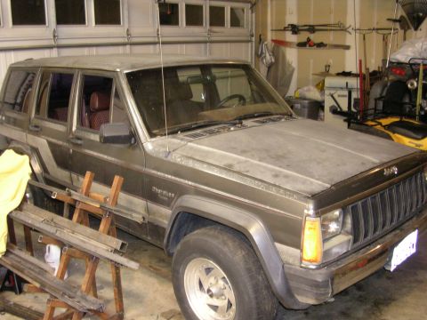 1987 Jeep Cherokee - A 1987 Jeep Cherokee is parked inside a garage, showing its front 3/4 view.