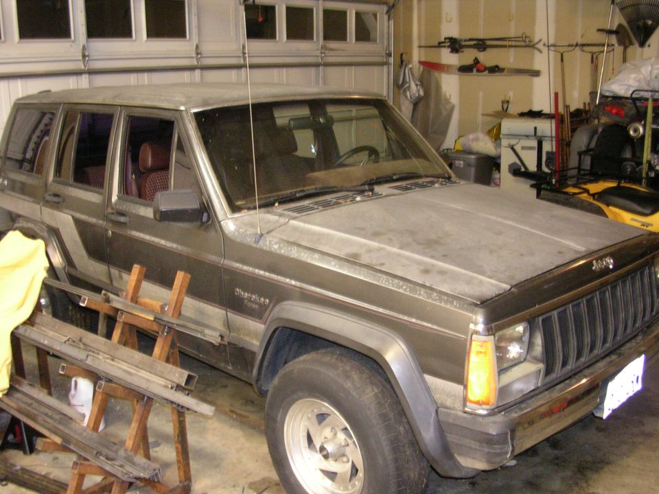 1987 Jeep Cherokee parked in a garage with the hood up