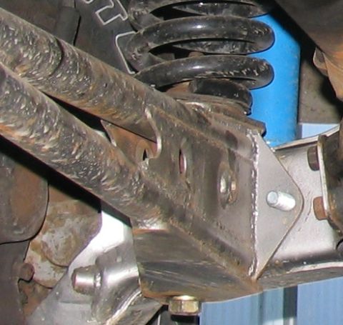 1984 Ford Bronco - Close-up view of vehicle suspension parts, including a coil spring and shock absorber.