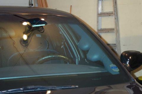 1998 Ford Crown Victoria - The interior of a car is visible through the windshield, with a ladder in the background.