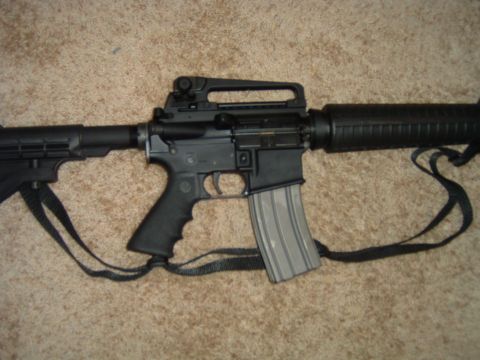 1992 Ford Probe - A close-up view of an assault rifle, likely an AR-15 variant, is shown against a carpeted background.