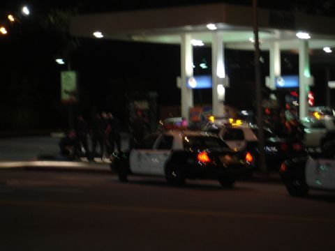 1993 Ford Taurus - Several police vehicles are visible at a gas station during nighttime hours, with officers standing nearby.