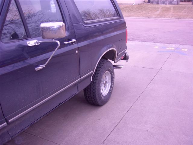 Dark blue SUV side view, showing chrome mirror and trim