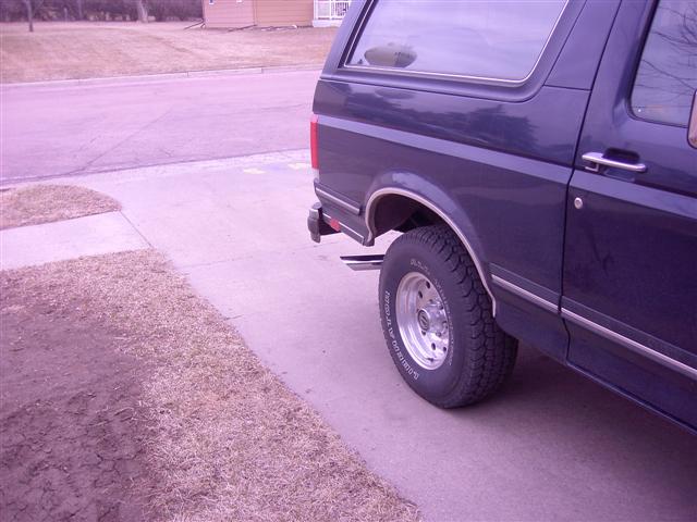 Dark blue SUV parked on a driveway, showing the rear wheel and side panel