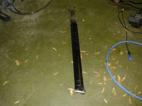 1993 Ford Bronco - A driveshaft is shown on a floor, possibly in a garage or workshop setting.