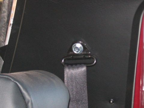 1991 Ford Bronco - Close-up of a seatbelt anchor point within a vehicle's interior.