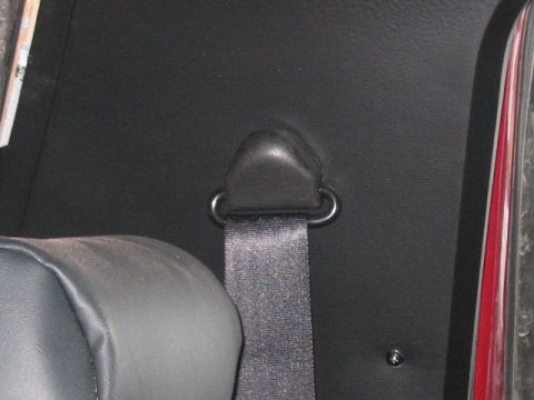 1991 Ford Bronco - Close-up view of a seatbelt anchor point on the interior panel of a vehicle.