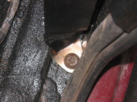 1991 Ford Bronco - Close-up of a seatbelt anchor with a visible part number, likely from the interior of a vehicle.