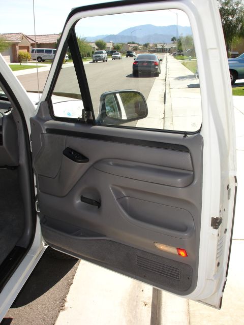 1996 Ford Bronco - View from inside a 1996 Ford Bronco, looking out the open door at the street and other vehicles.