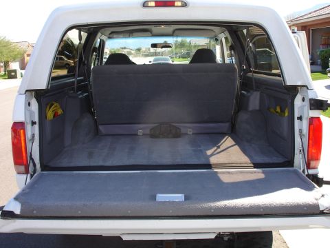 1996 Ford Bronco - The open tailgate reveals the spacious cargo area of the Ford Bronco, with seats folded down.