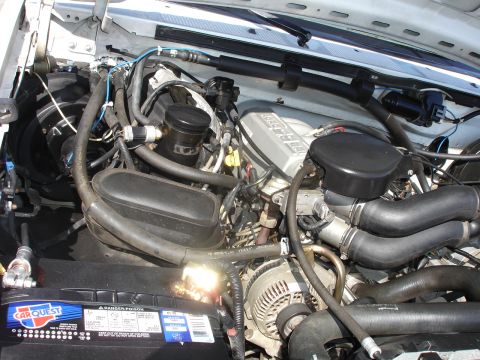 1996 Ford Bronco - The engine bay of a 1996 Ford Bronco is visible, with the V8 engine, battery, and associated components clearly depicted.