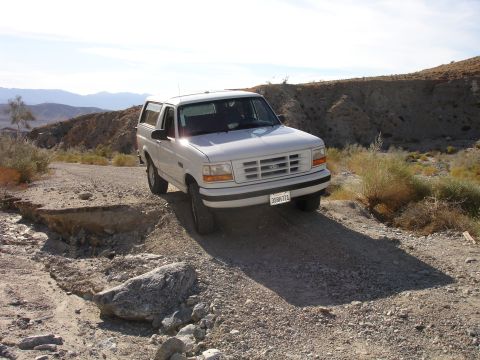1996 Ford Bronco - This 1996 Ford Bronco navigates a rough dirt road, its off-road capability in a dry, mountainous terrain.