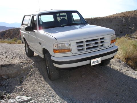 1996 Ford Bronco - 1996 Ford Bronco on a dirt road in a desert landscape.