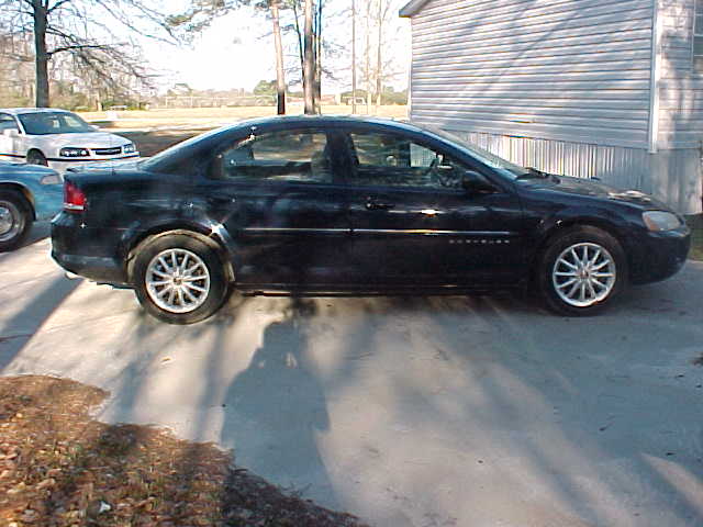 Black sedan parked next to a white car and a blue car