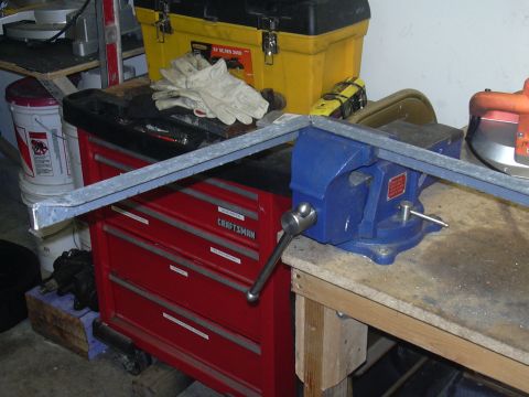 1991 Ford Bronco - A metal bar is secured in a blue vise, ready for work on a workbench.