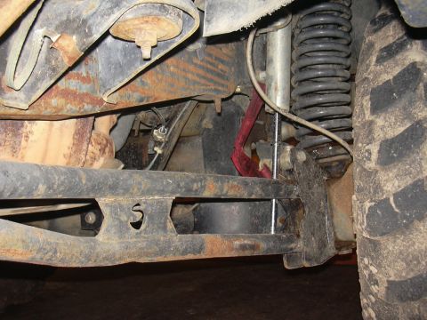 1991 Ford Bronco - Close-up view of the undercarriage of a vehicle, showing suspension parts and a tire.