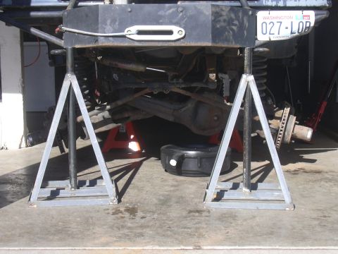 1991 Ford Bronco - A 1991 Ford Bronco is raised on jack stands for maintenance, revealing its front suspension and undercarriage.